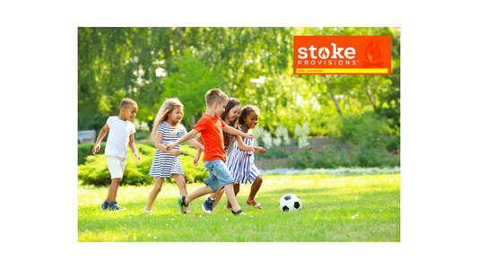 A diverse group of children and parents enjoying outdoor activities in a lush park, with a focus on healthy snacking and sustainability.