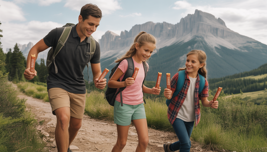 A family hiking in a mountain landscape, each holding Stoke Provisions' snack sticks, highlighting their use as adventure snacks.